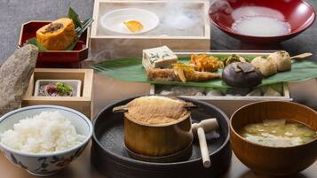 A traditional Japanese meal setup with various dishes including rice, soup, and pickled vegetables.