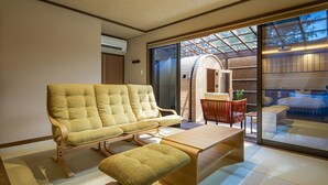 A modern interior with a sofa and bench, a small table, and a view through a glass door to a bedroom. - Takachiho Hanareno-yado Kamigakure (Takachiho)