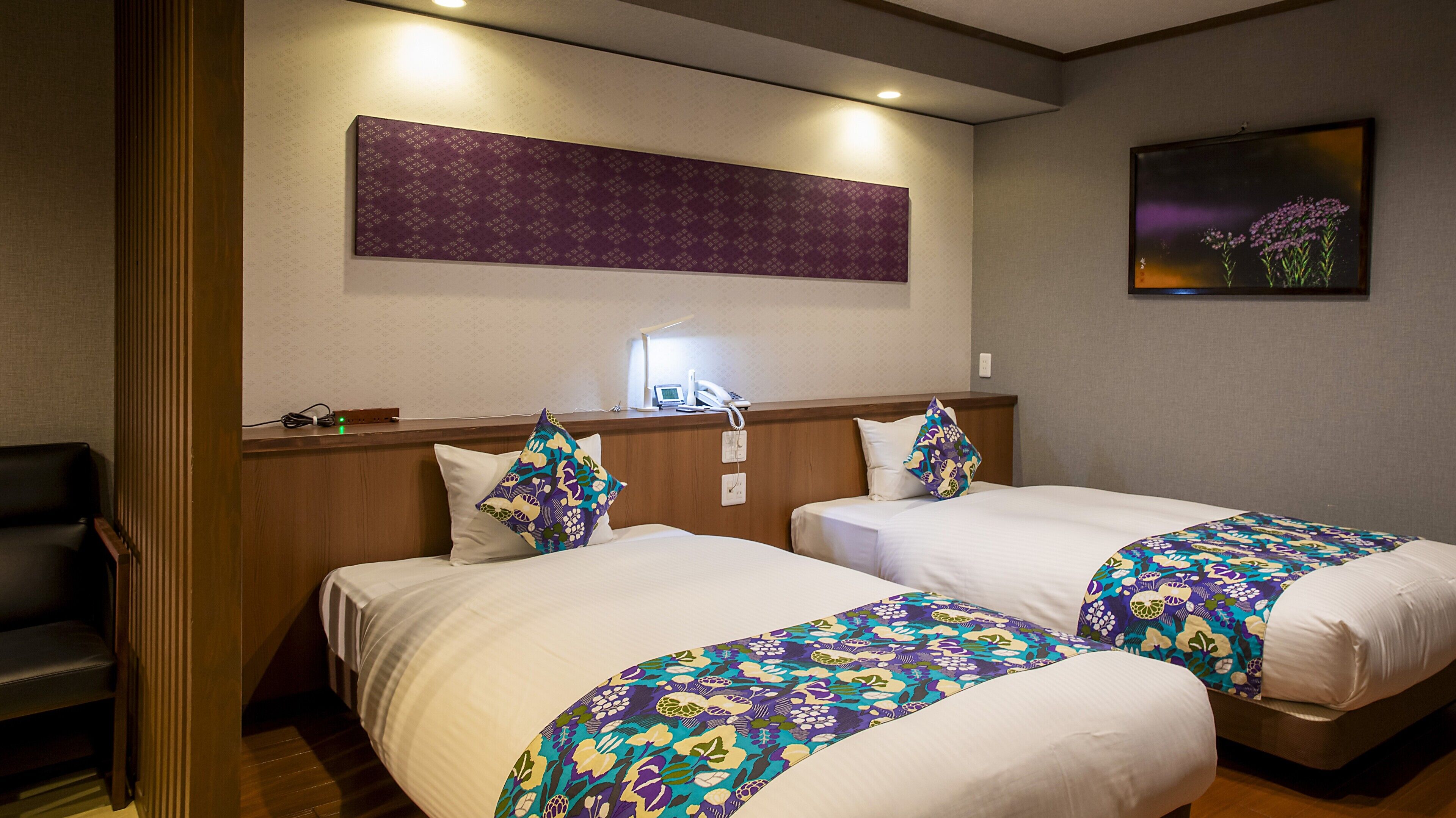 A hotel room with two beds, a desk, a chair, a phone, and a painting on the wall.