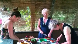 A group of people preparing food outdoors with various ingredients and utensils on a table. - Habarana Ambasewana Resort (Habarana)