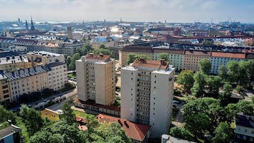 A high-rise building with multiple floors, surrounded by trees and other buildings.