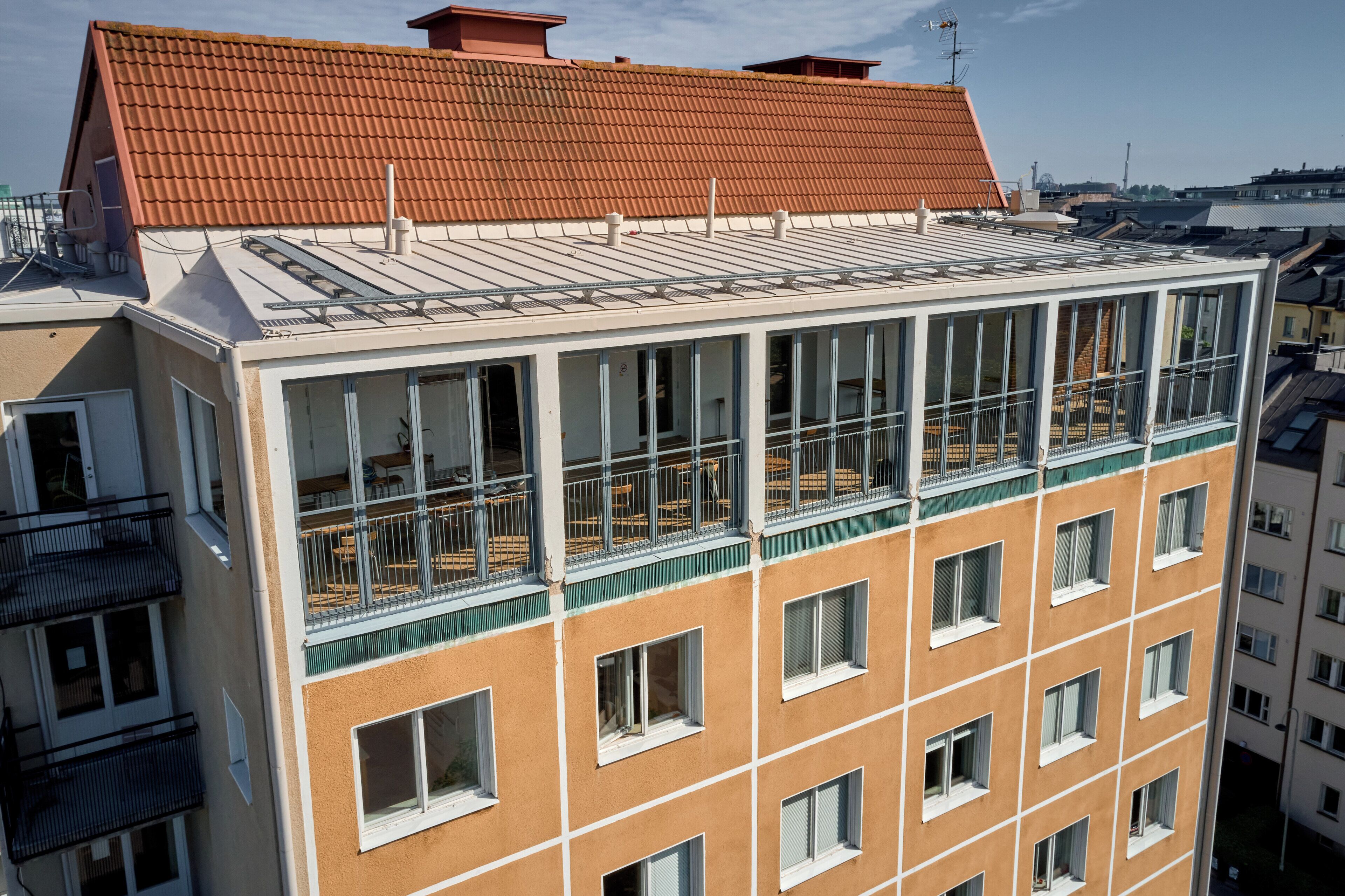 Un edificio de varios pisos con techo plano, ventanas grandes y balcones.