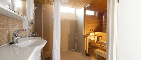 Un baño moderno con techo de madera, un lavamanos blanco, una ducha con cortina y un banco.