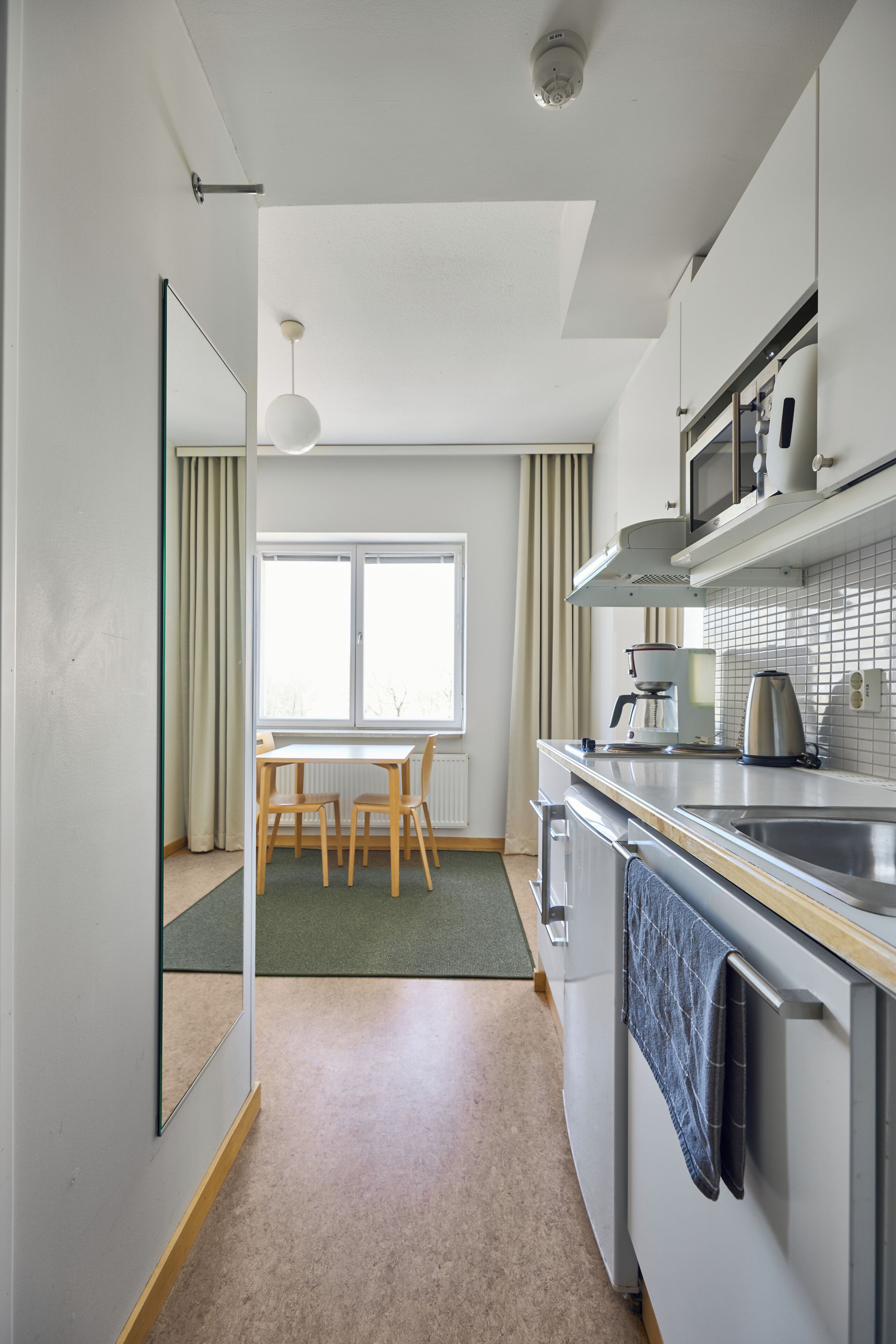 Una cocina moderna con comedor, microondas y hervidor.