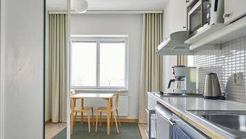 Una cocina moderna con comedor, microondas y hervidor.