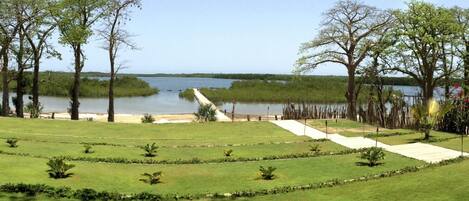 A landscaped garden with pathways, trees, and a view of a lake.