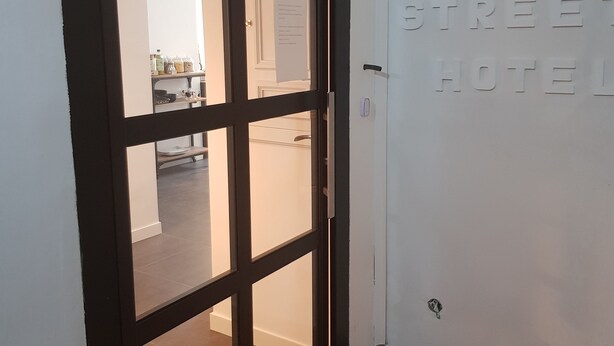 A hotel entrance with a glass door and a sign reading "ART STREET HOTEL". - Art Street Hotel (Naples)