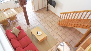 A compact living space with a red sofa, a wooden coffee table, and a wicker chair. - Amazing apartment in Ystad with WiFi (Ystad)