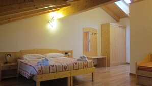 Un dormitorio con una cama de madera, una mesita de noche, un escritorio y un armario.