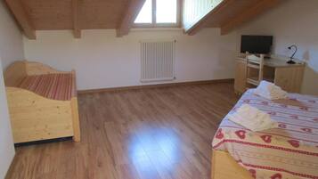 Una habitación con una cama de madera, un escritorio de madera, un radiador y una ventana.