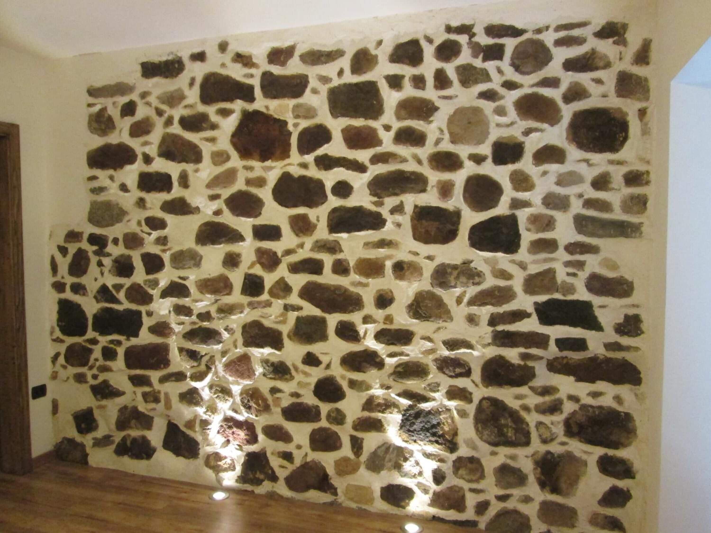 Ein Zimmer mit Steinwand und Holzboden.