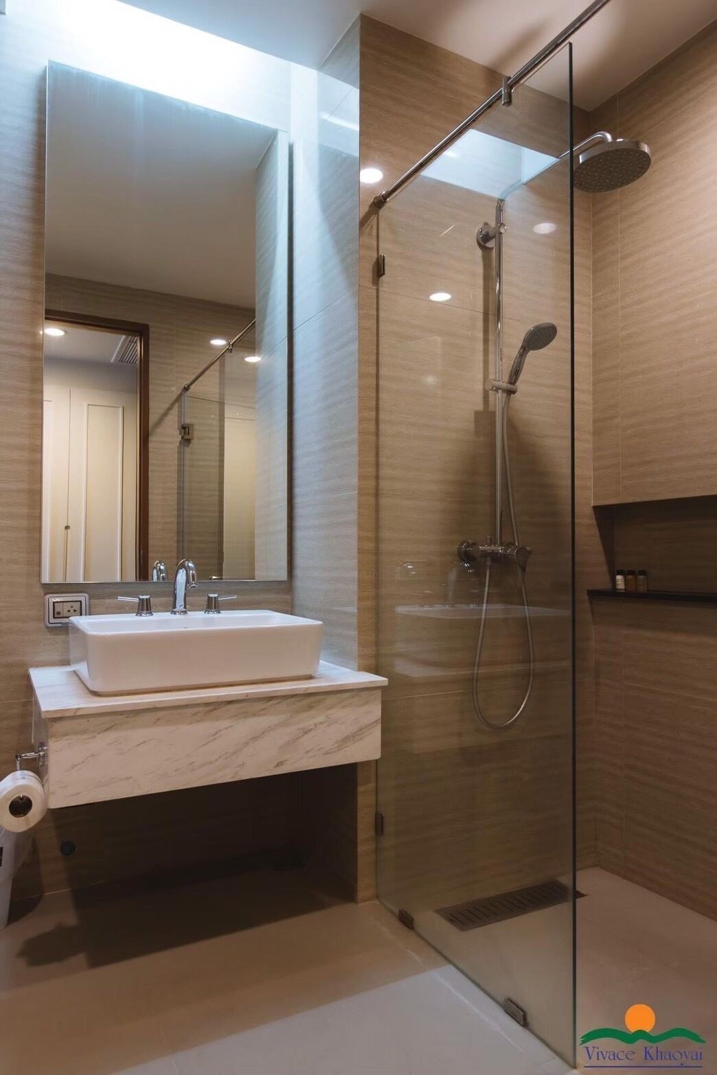 A modern bathroom with a glass-enclosed shower, a marble sink, and a large mirror.