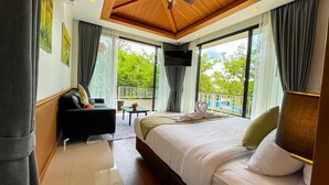 A modern hotel room with a large bed, a sofa, a small table, and a balcony with a pool view. - Vivace Khaoyai Resort (Pak Chong)