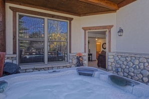 A hot tub area with stone walls and a wooden ceiling, large windows, and a stone fireplace. - Corral 3bd/3ba , Downtown Breckenridge, 3 King Beds, Walk to Ski Lift, Hot Tub (Breckenridge)