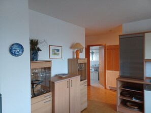 A kitchen with wooden cabinets, a sink, and a dish rack.