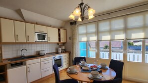 Una cocina con una mesa de comedor dispuesta para cuatro personas, microondas, horno y cafetera.