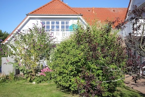 A house with a red roof, white exterior, and a garden with various plants and flowers. - Abels Strandkoje, Germany (Wustrow)