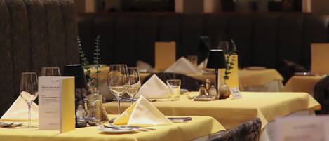 A restaurant with tables set for dining, featuring a classic interior with arched windows and a warm ambiance.