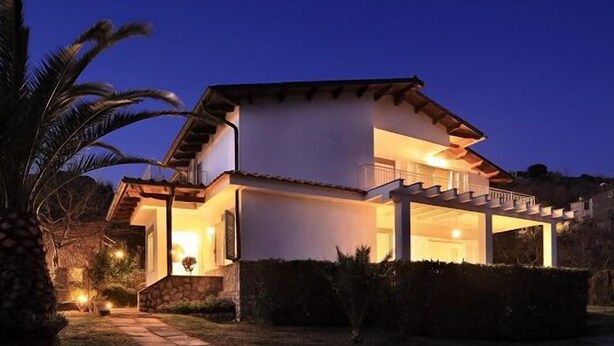 A modern two-story house with a balcony and a covered porch, surrounded by well-maintained landscaping. - Relais Gea (Massa Lubrense)