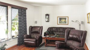 A living room with two leather armchairs, a sofa, a wooden coffee table, a clock, and a framed picture on the wall. - 3 bedroom cozy home in Vimmerby (Vimmerby)
