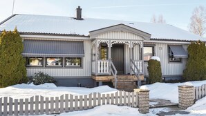 A two-story house with a covered porch, a chimney, and a number '23' on the side. - 3 bedroom cozy home in Vimmerby (Vimmerby)