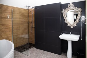 A modern bathroom with a glass shower enclosure, a white sink, and a large mirror with an ornate frame. - Hotel Wodnik (Wroclaw)