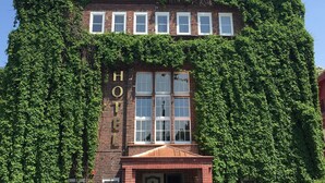 A building with the sign "HOTEL WODNIK" and ivy-covered walls. - Hotel Wodnik (Wroclaw)