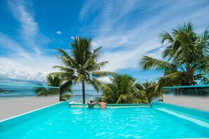 Ein klarer, blauer Himmel, ein Schwimmbecken und Palmen.