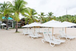 Perto da praia, espreguiçadeiras, guarda-sóis, toalhas de praia 