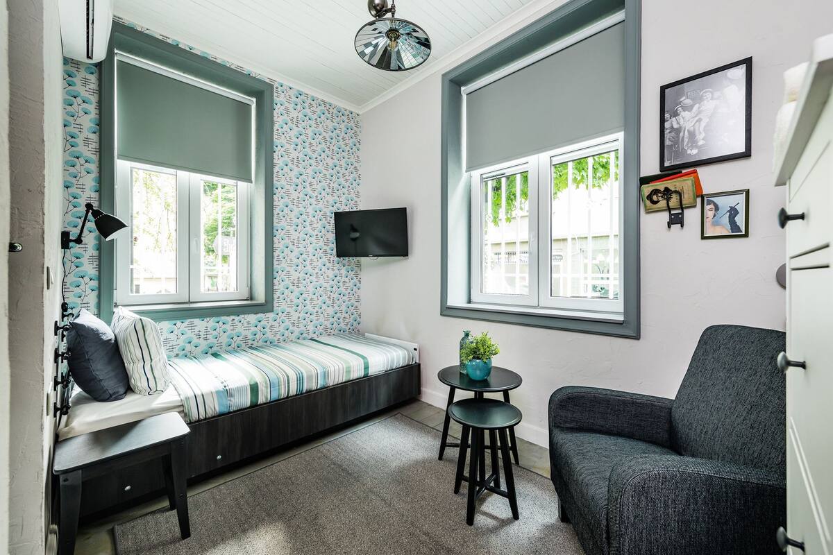 A cozy room with a built-in bench, a small table with a plant, and a chair.
