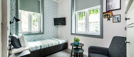 A cozy room with a built-in bench, a small table with a plant, and a chair.