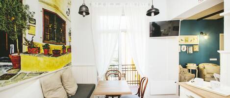 Ein gemütliches Interieur mit Essbereich, einer Bank mit Kissen und einem Tisch mit Stühlen.