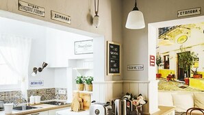 Una cocina moderna con armarios blancos, una isla de madera y un comedor con mesa y sillas.