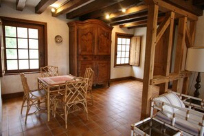 A dining area with a table and chairs, wooden cabinets, and a window.