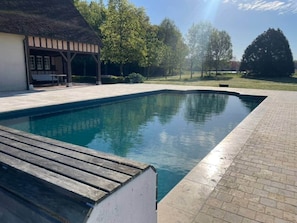A swimming pool with a wooden deck, a covered seating area, and a brick pathway. - Large spacious and relaxing house with  pool, tennis and pond - up  to 16p: Deer (Monthou-sur-Cher)