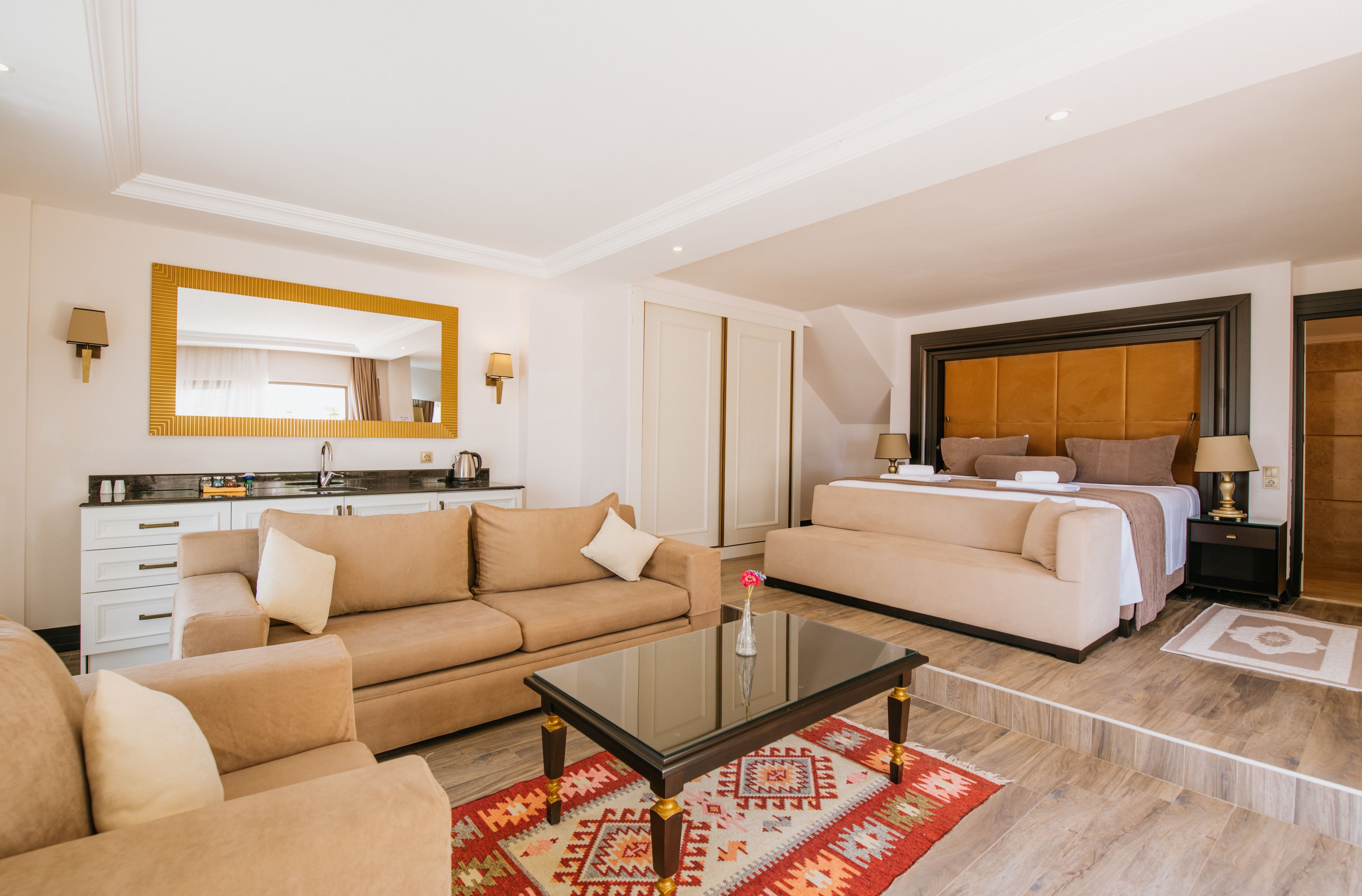 Habitación de hotel moderna con sala de estar, dormitorio independiente, cocina y baño.