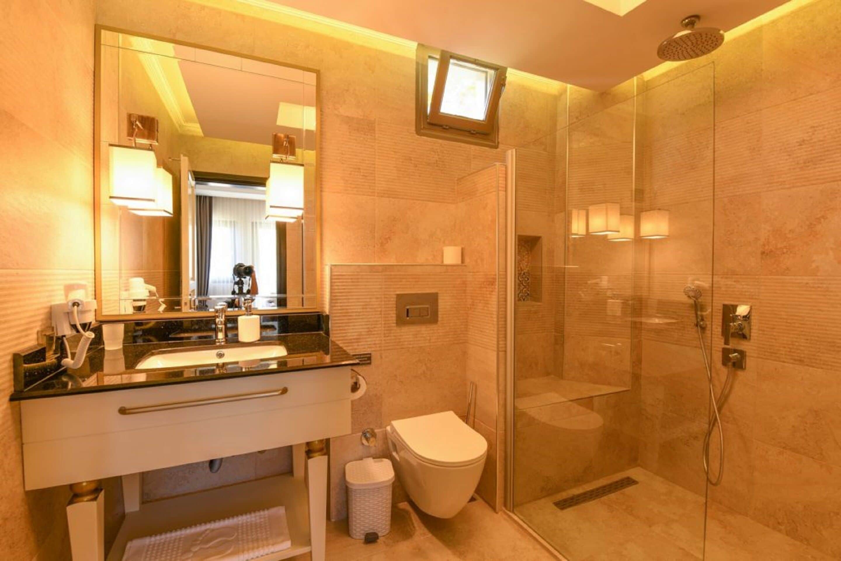 A modern bathroom with a glass-enclosed shower, a sink with a vanity, and a toilet.