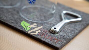 A felt coaster with a metal bottle opener and a logo.