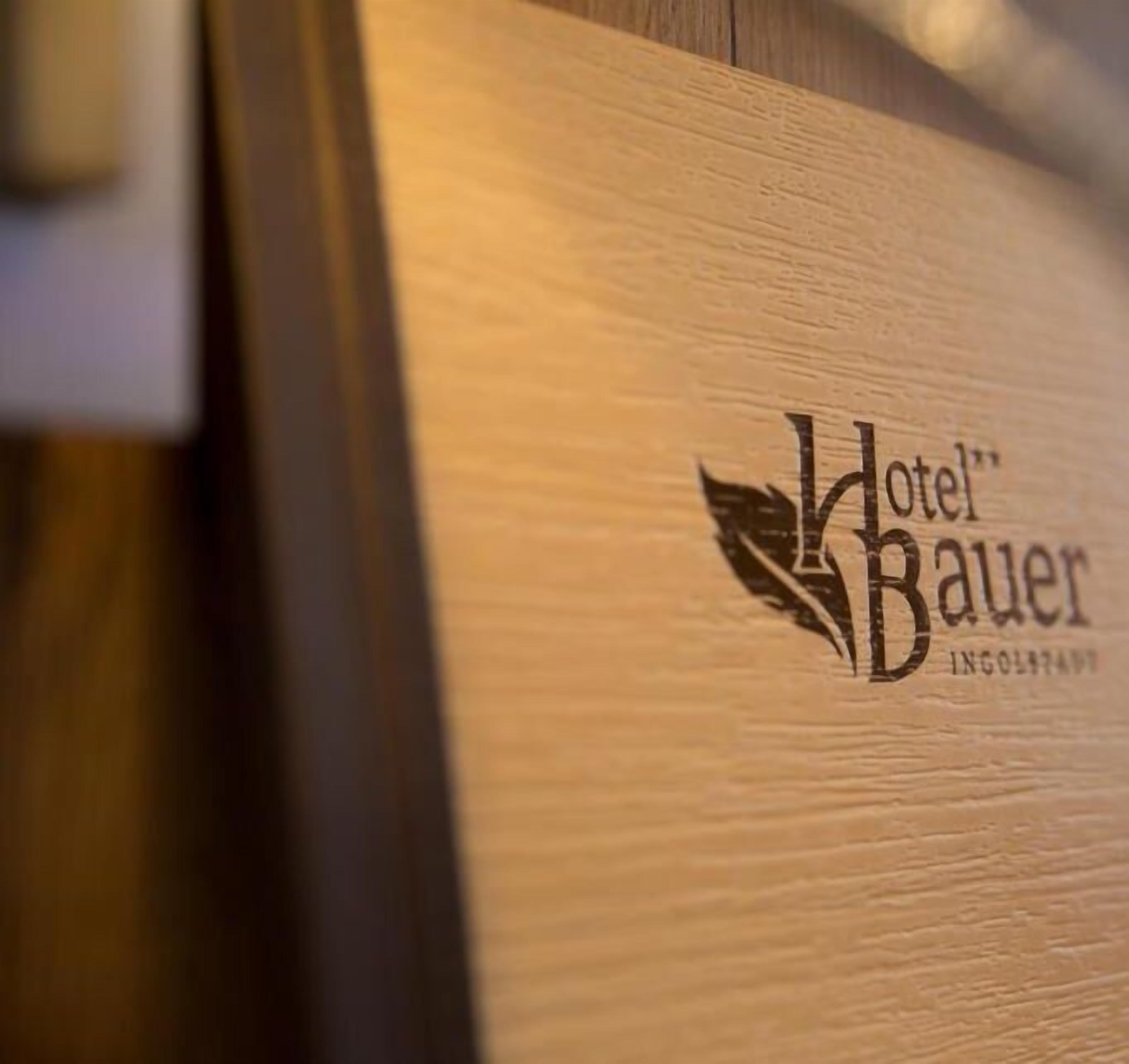 A wooden panel with the logo and name "Hotel Bauer" and the word "INGOLSTADT" below it.