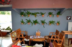 A dining area with wooden furniture and a wall decorated with potted plants. - Pousada Santa Maria (Tiradentes)