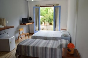 A bedroom with two beds, a TV, a desk, and a chair. - Pousada Santa Maria (Tiradentes)