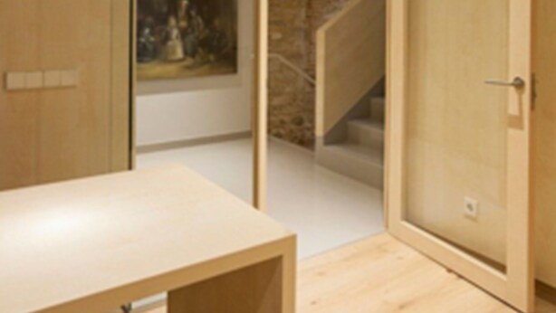 A modern room with a wooden desk, a hanging light fixture, and a large mirror. - San Gil Plaza Hotel (Zamora)