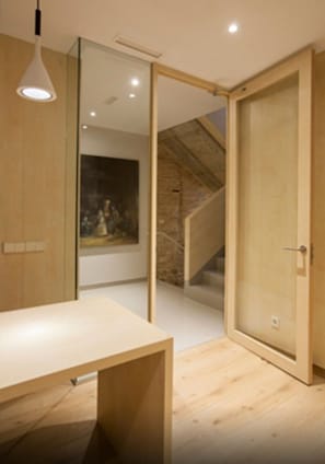 A modern room with a wooden desk, a hanging light fixture, and a large mirror. - San Gil Plaza Hotel (Zamora)