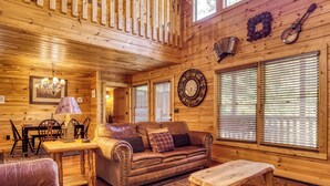 L’intérieur d’un chalet accueillant, avec un canapé en cuir, une table en bois et un banc.