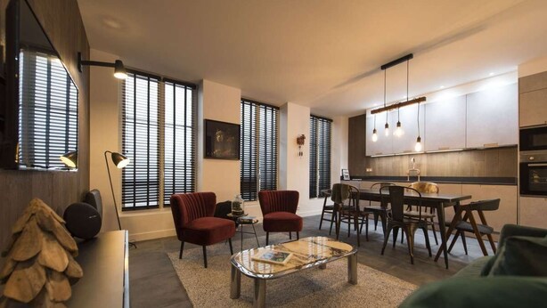 A modern living room with a coffee table, red chairs, and a dining area with a table and chairs. - Heidi, 2BR/2BA, 6 people (París)