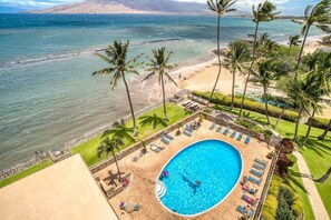 Un resort con piscina, spiaggia e palme.
