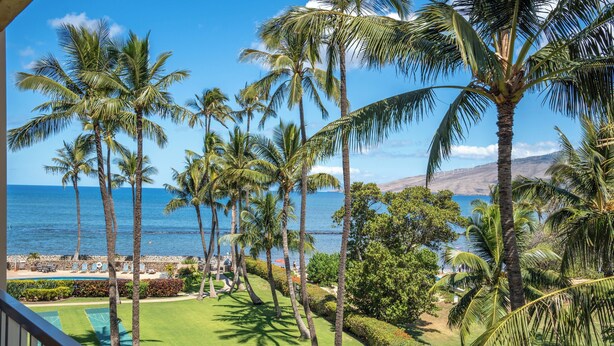 A tropical resort with palm trees, a pool, and a view of the ocean. - Menehune Shores #401 4th floor Ocean View, A/C throughout, Great Rates (Kihei)