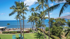 A golf course with a view of the ocean and palm trees. - Menehune Shores #401 4th floor Ocean View, A/C throughout, Great Rates (Kihei)