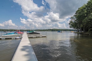 Guests can access boats from the dock, surrounded by a tranquil lakeside setting with trees.