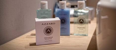 Exposição de frascos de sabonete perfumado Azzaro e uma caixa sobre uma superfície de madeira.